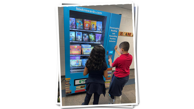 "Principal for a Day" students choosing book from vending machine.