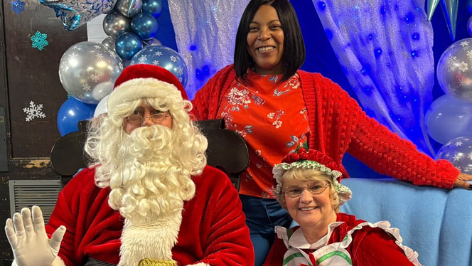 Mr. and Mrs. Claus smile with school staff.
