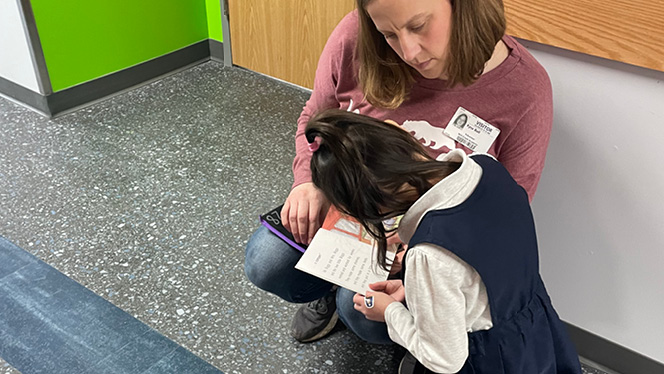 K-8 School in Waukesha: Second-grader Ruby Olson reads with a parent volunteer.