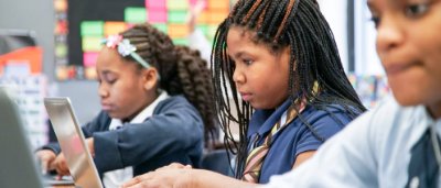 K-8 School in Cincinnati: Students sitting at desk working on their laptops.