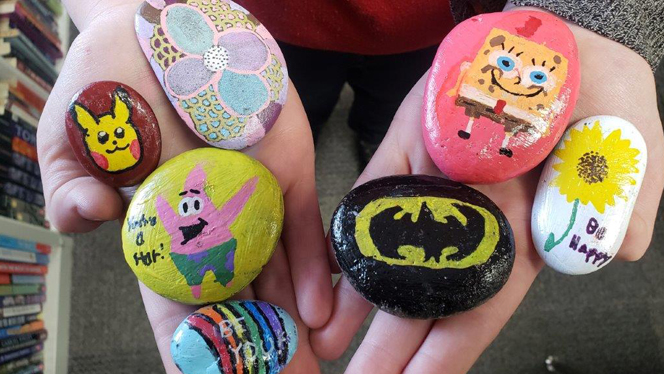 Students holding painted rocks.
