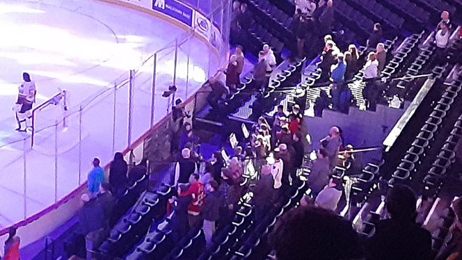 Students playing instruments at a hockey game.